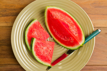 Watermelon on plate over wooden background