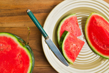Watermelon on plate over wooden background