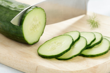 Salatgurke wird in Scheiben geschnitten
