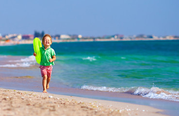 Fototapeta na wymiar happy boy running the beach surf, expressing delight