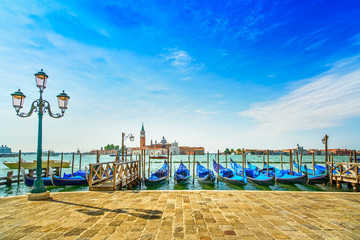 Venice, street lamp and gondolas or gondole and church. Italy