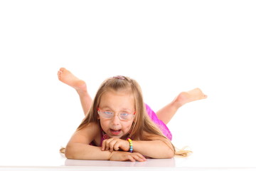 Fototapeta premium cute little girl lying on the floor doing fun isolated
