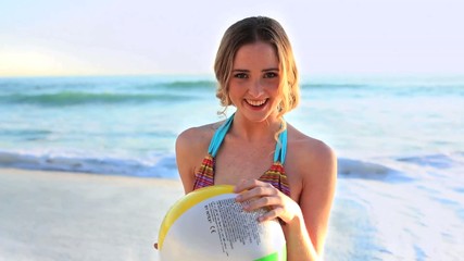Cute blonde model in swimsuit playing with a beachball - Powered by Adobe