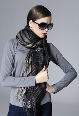 Portrait of young woman in sunglasses with scarf posing