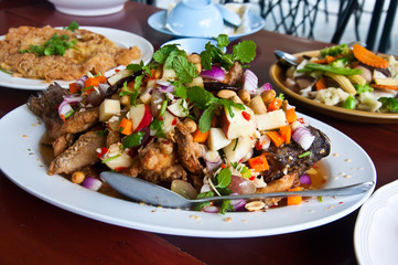 Herb salad with deep fried fish and lemongrass. Thai food.