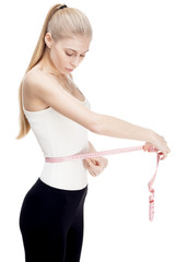 young blond woman measuring waist