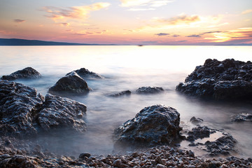sunrise on rocky sea coast and blurred water