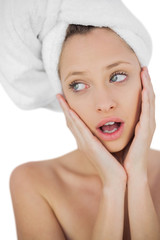 Schocked brunette drying her hair looking away