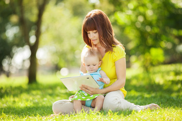 Happy family, mother and daughter with tablet resting in the par