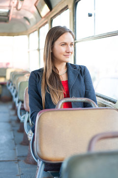 Beautiful young woman sitting in vintage bus