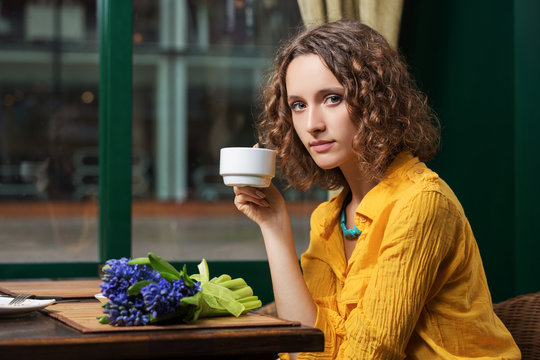 Sad Young Woman Drinking Tea At Restaurant