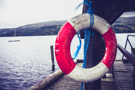 Life buoy hanging on pier at lake