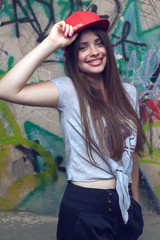Fototapeta premium smiling beautiful girl posing near painted wall.