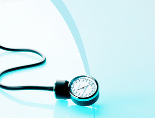 Sphygmomanometer on blue, reflective background