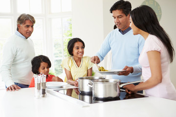 Multi Generation Indian Family Cooking Meal At Home