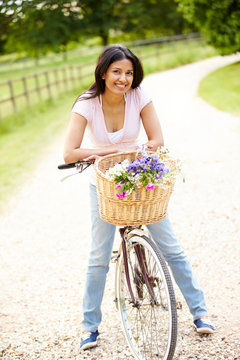 Indian Woman On Cycle Ride In Countryside