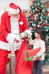Santa Claus Giving Gifts To Girl