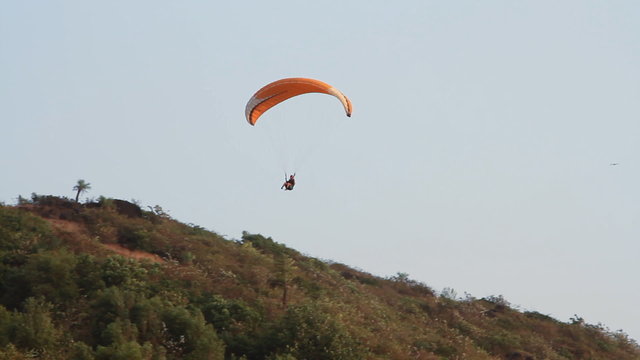 Paragliding over the mountains against clear blue sky