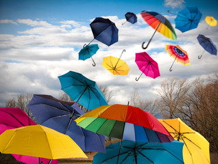 Herbsttag: Stürmisch und wolkig mit vielen bunten Regenschirmen