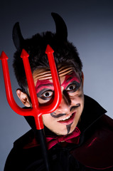 Man in devil costume in halloween concept
