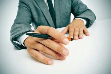 man in suit with a pen in his hand