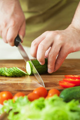 man cutting vegetables for salad