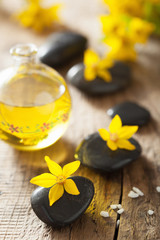 Obraz na płótnie Canvas spa stones essential oil and yellow flowers for spa