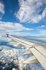Obraz premium Airplane Wing against Blue Sky and Clouds