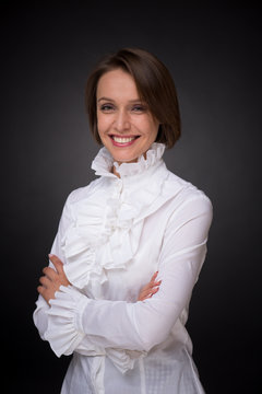 Smiling Woman In White Shirt Frill On Dark Grey Background