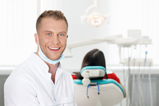 Cheerful dentist. Smiling young dentist looking at camera while