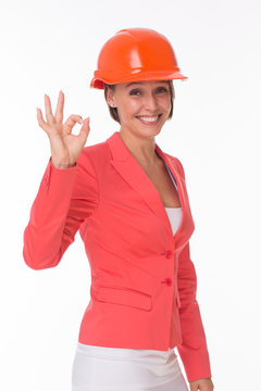 Business woman in helmet and jacket show Okay isolated on white