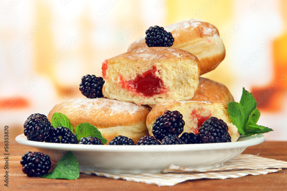 Poster Tasty donuts with berries on wooden table