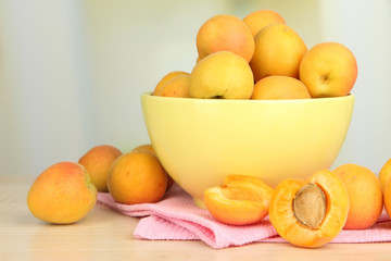 Fresh natural apricot in bowl on table in kitchen