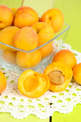 Fresh natural apricot in bowl on green wooden table