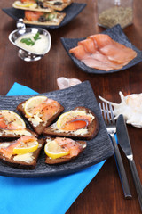 Salmon sandwiches on plate  on wooden table close-up