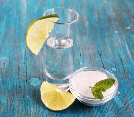 Tequila in glass on wooden table close-up
