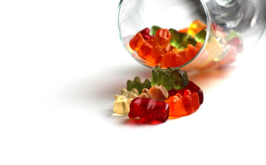 Fruit gummy bear candies falling from a wine glass