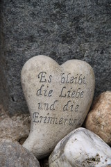 Herzförmiger Stein mit Inschrift auf einem Grab