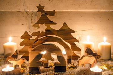 Frohe Weihnachten: Holzkrippe mit Kerzenlicht
