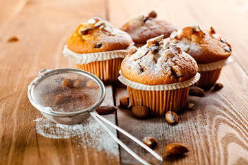 Muffins with almonds on a wooden table