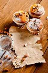 Muffins with almonds on a wooden table