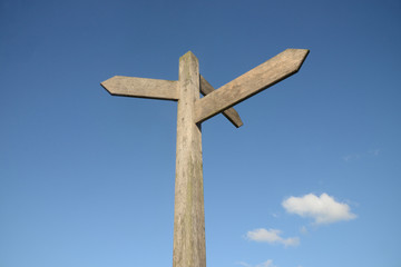 Blank signpost with blue sky and clouds
