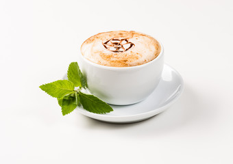 large cup of coffee and green leaf of mint