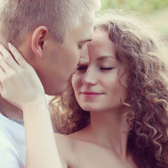 Fototapeta premium happy young couple kissing and hugging 