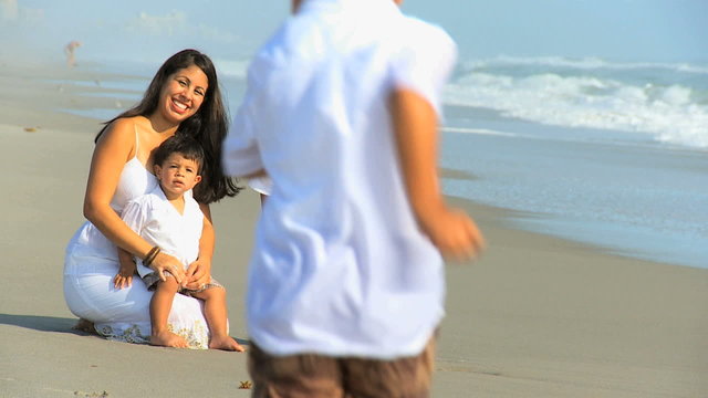 Young Hispanic Family Playing Sand Beach