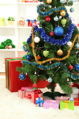 Decorated Christmas tree on home interior background