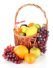 Different fruits in wicker basket with juice isolated on white