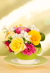 Beautiful bouquet of bright flowers in color mug,