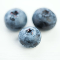 Macro shot of ripe blueberries on white wooden background