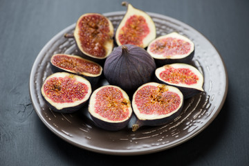 Ceramic plate with sliced ripe fig fruits, horizontal shot